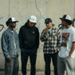 Quatro homens usam bonés snapback astredik de aba reta em diferentes cores, posando juntos num ambiente urbano.