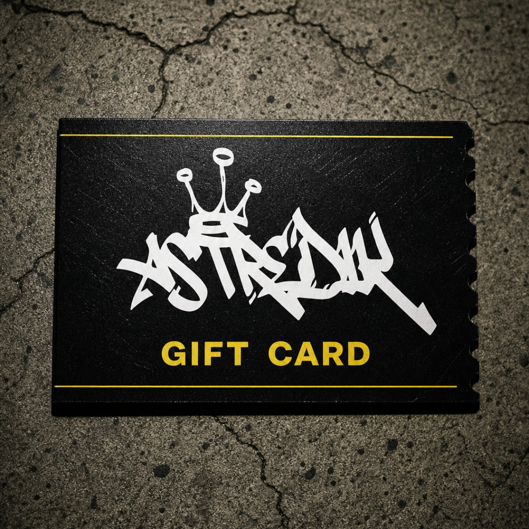Cartão presente digital astredik preto com logótipo em graffiti branco e detalhes em amarelo sobre fundo de cimento.