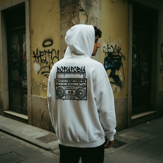 Homem de costas a usar hoodie branco astredik com ilustração de rádio e texto Bofiofobia num cenário urbano
