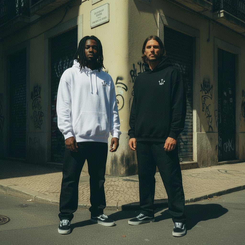 Dois modelos usam hoodies astredik UNIFORM 00 em branco e preto com logótipo bordado, em ambiente urbano.