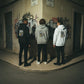 Três modelos astredik vestem hoodies da coleção Bone Crew com estampado de caveira urbana em fundo de graffiti